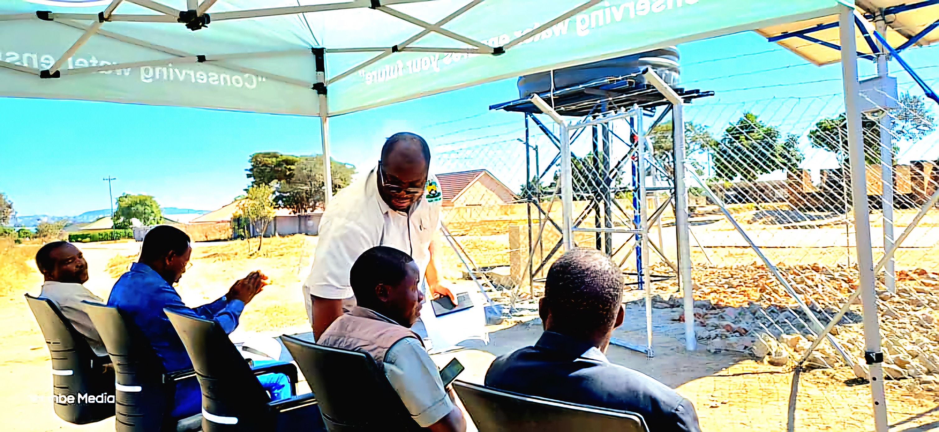 Officials seated near the solar borehole installation